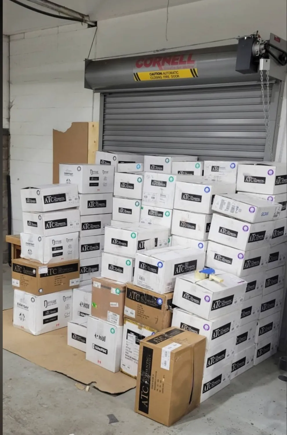 Dozens of boxes of blank apparel stacked in the Sandstar Graphics shop, ready for a 6,000 piece team order